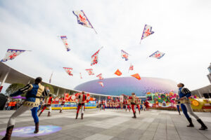 Sedici sbandieratori dei Bandierai degli Uffizi eseguono un lancio incrociato dietro la schiena al Kai Tak Stadium di Hong Kong
